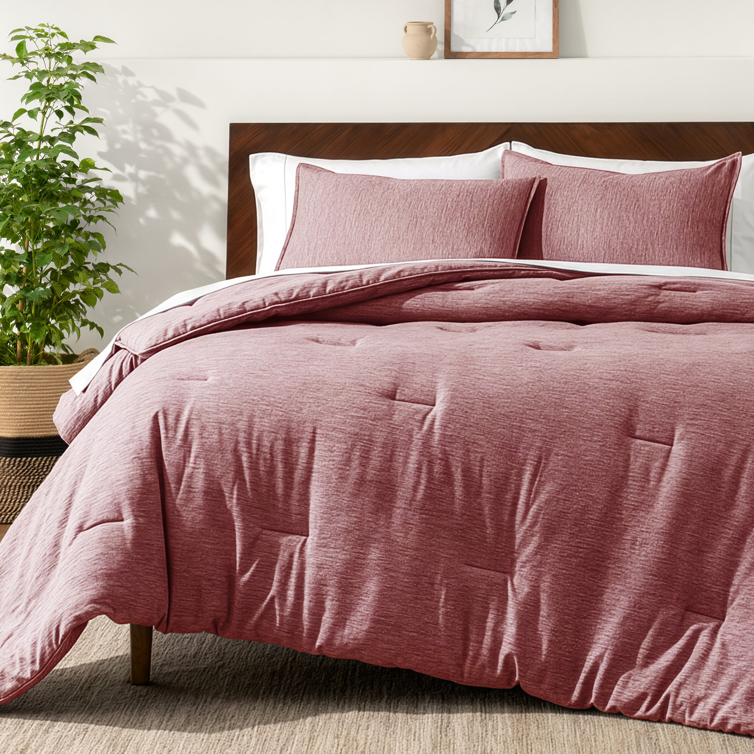 Bedding set on a bed in a bedroom with a side table and lamp.