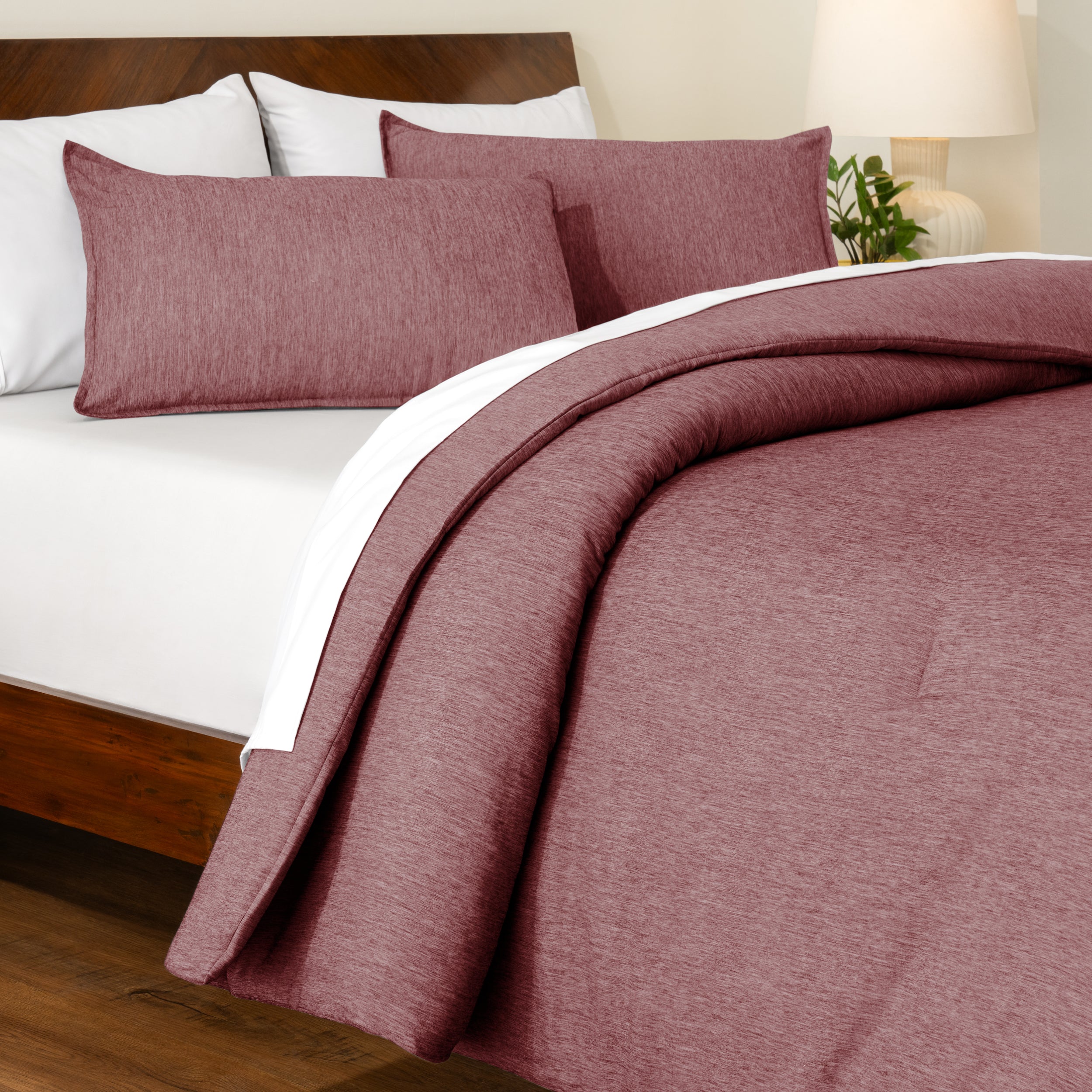 Track stitch comforter on a bed with white pillows and a wooden headboard.