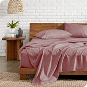 Bed with microfiber bedding against a white brick wall.