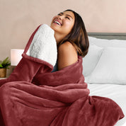 A woman smiling while wrapped in a sherpa blanket
