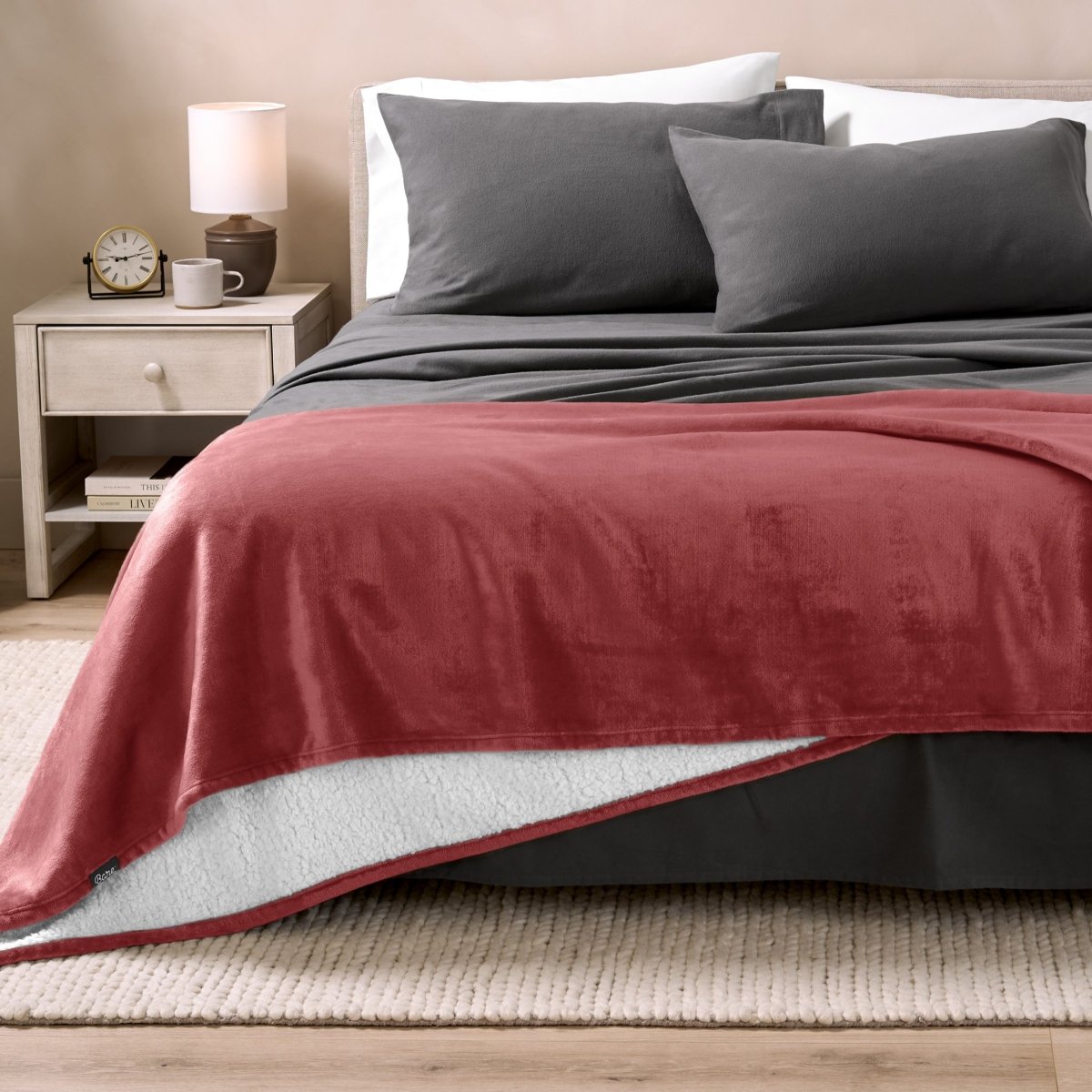 Bed with grey sheets and a sherpa blanket