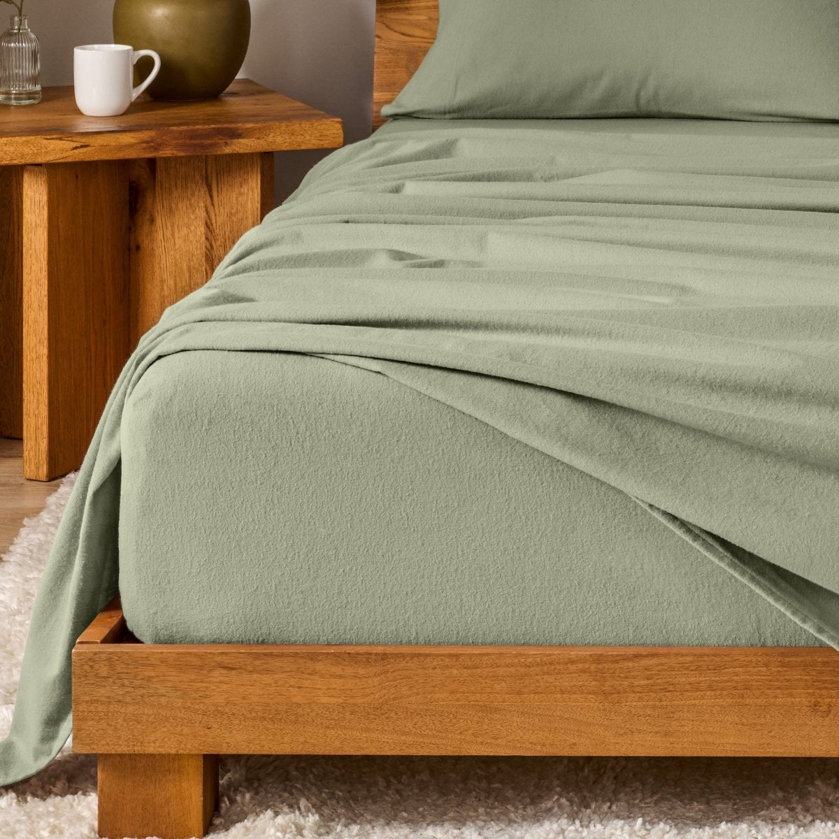 Bed with flannel bedding and wooden headboard and nightstand next to it.