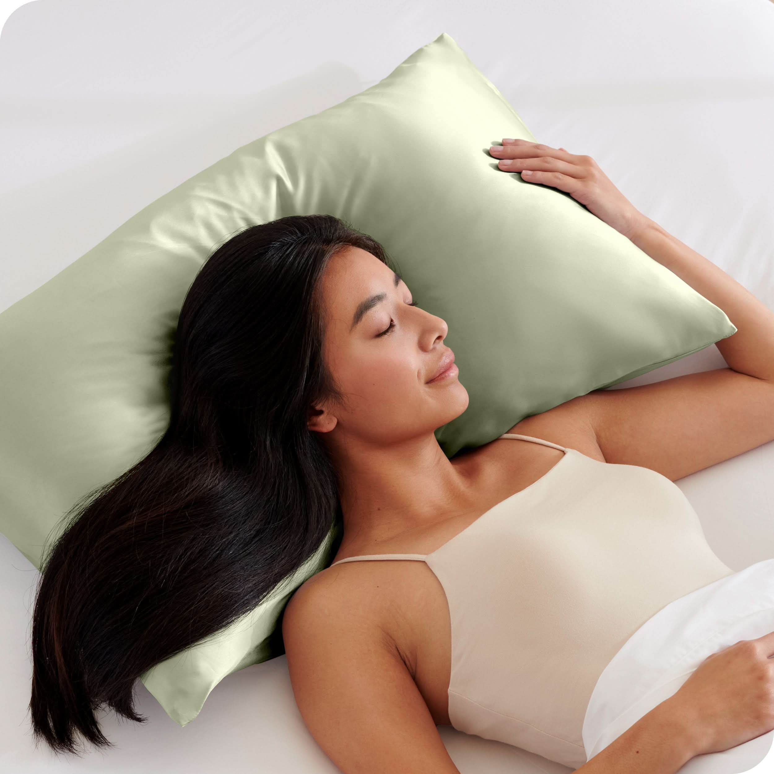 A woman is sleeping with her head on a silk pillowcase