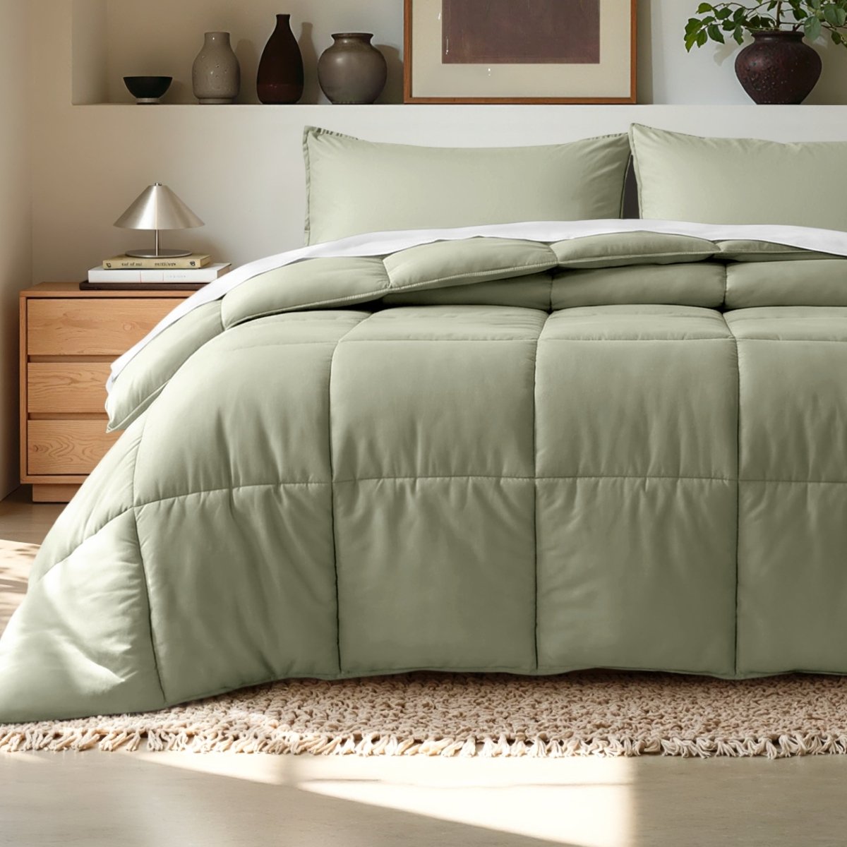 Comforter on a bed in a bedroom setting with a wooden nightstand and decorative items.