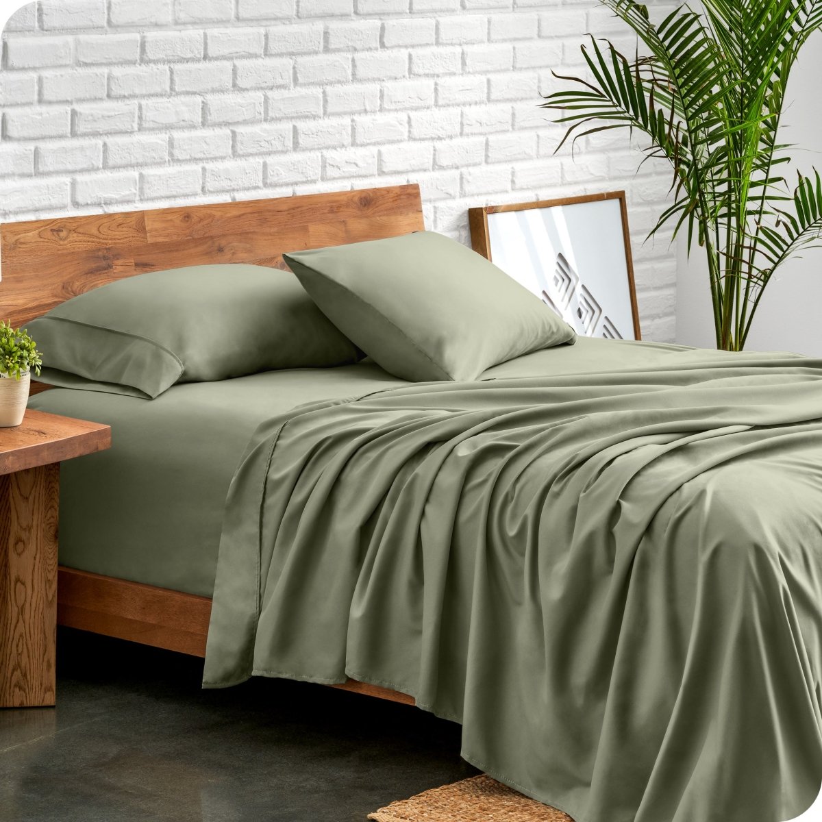 Bed with microfiber sheets against a white brick wall