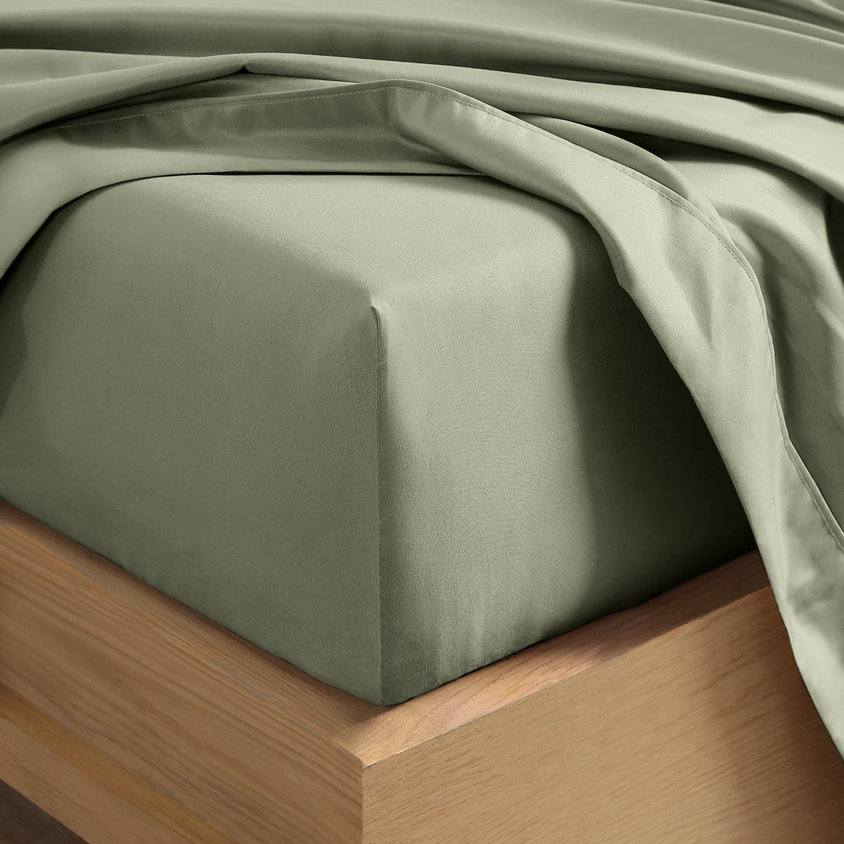 Close up of the corner of a mattress with a fitted sheet and flat sheet on it