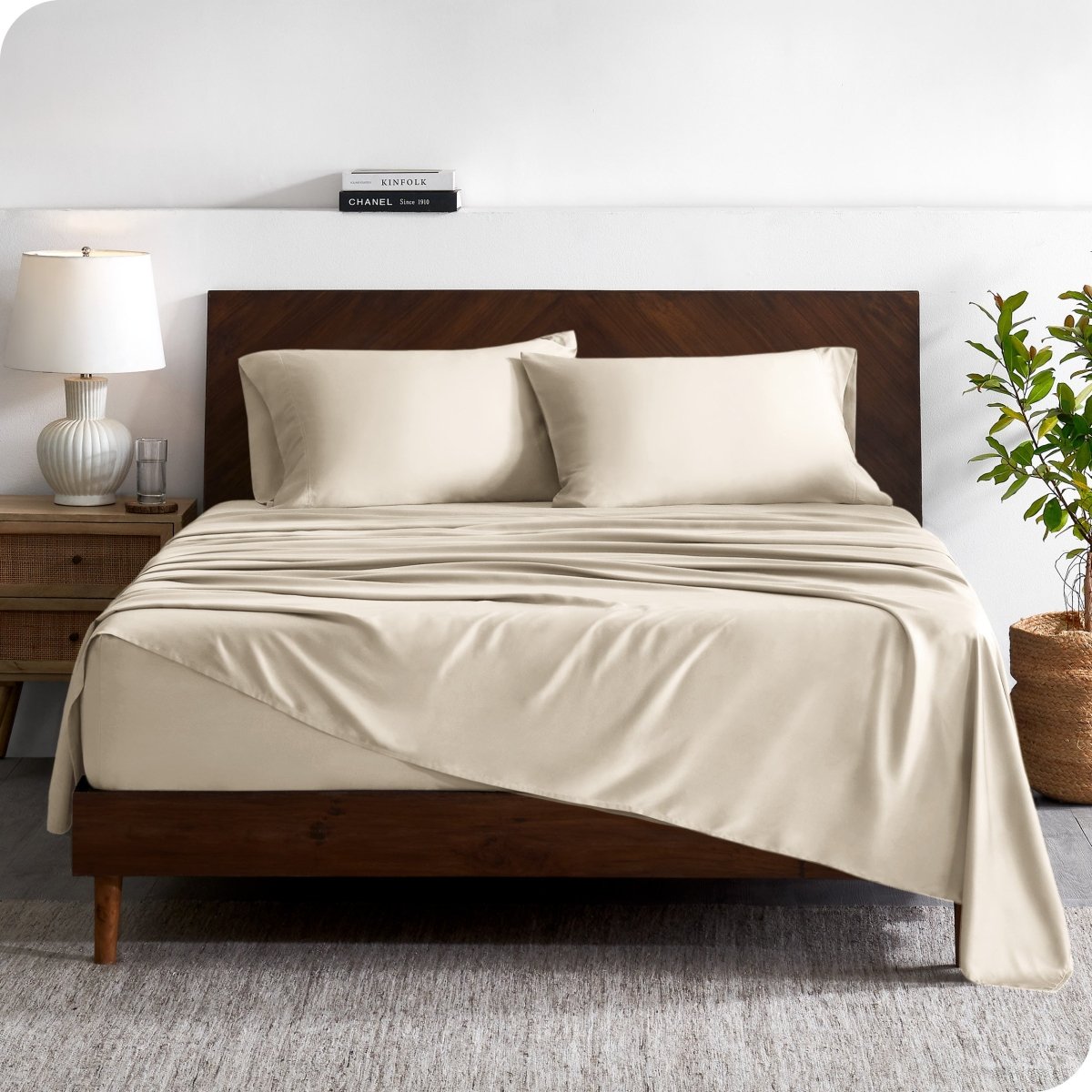 A contemporary bed with a sheet set and a wooden headboard.
