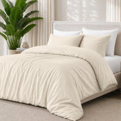 Sand bedding set on a bed with a plant in the background