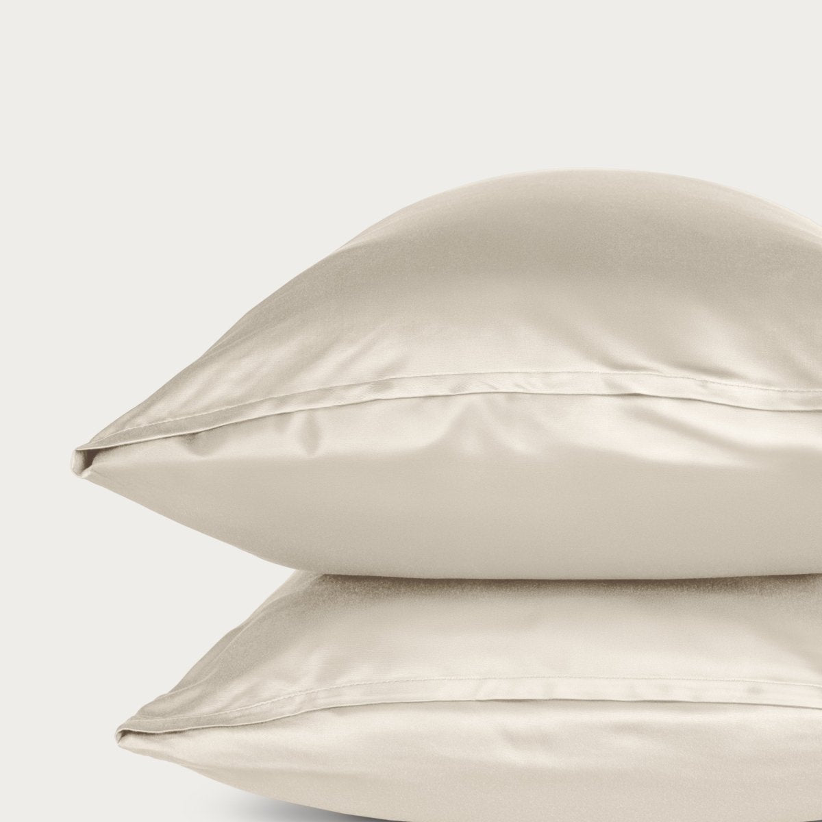 Bamboo pillowcase and bedding against a woven headboard with a plant in the corner.