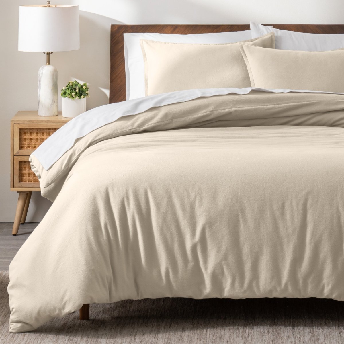 Flannel bedding set on a bed in a bedroom with a nightstand and lamp.