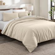 Flannel duvet cover set on a bed in a bedroom with a lamp and plant in the background.