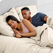 A couple sleeping with their heads resting on pillows with flannel pillowcases on them