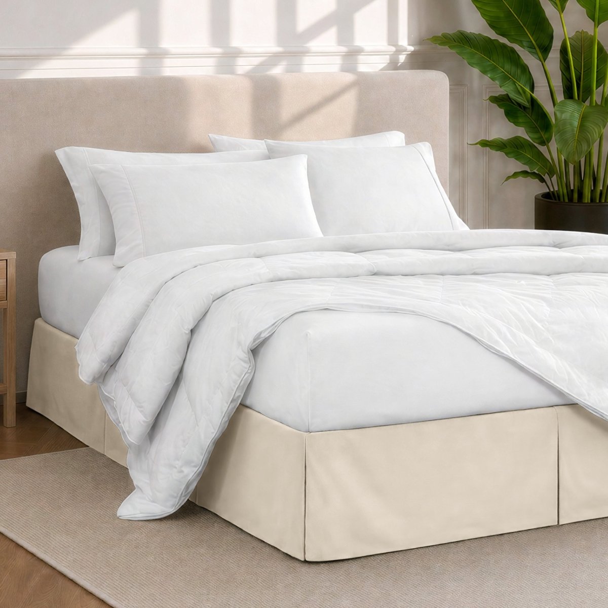 A modern bedroom with a bed skirt, comforter and sheets on the bed