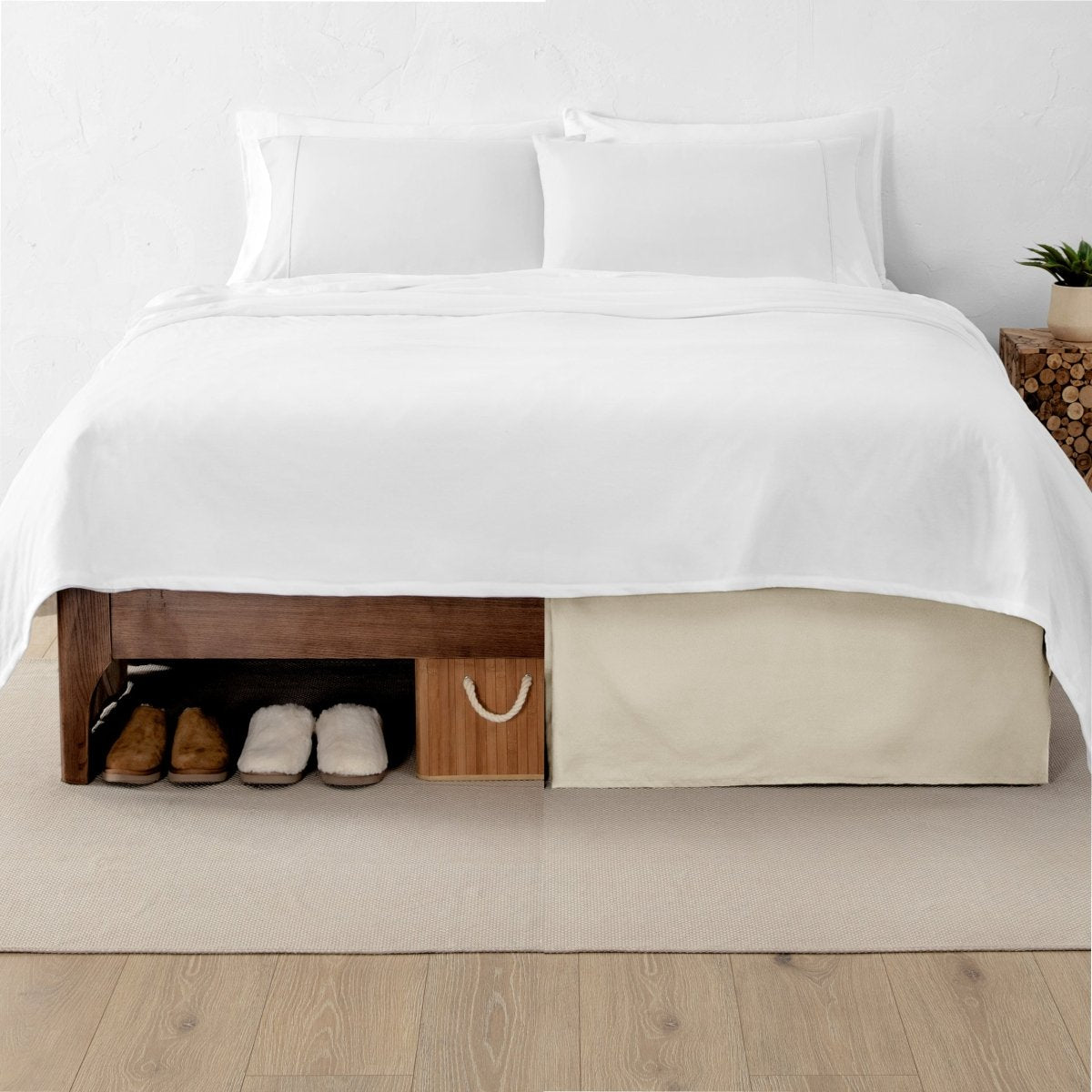 One side of a bed has shoes and a box under it while the other side has a bed skirt so that under the bed is hidden from view