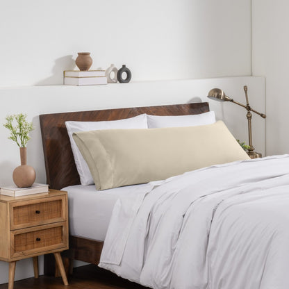 Bedroom with a wooden headboard and white bedding, featuring a nightstand and decorative items.