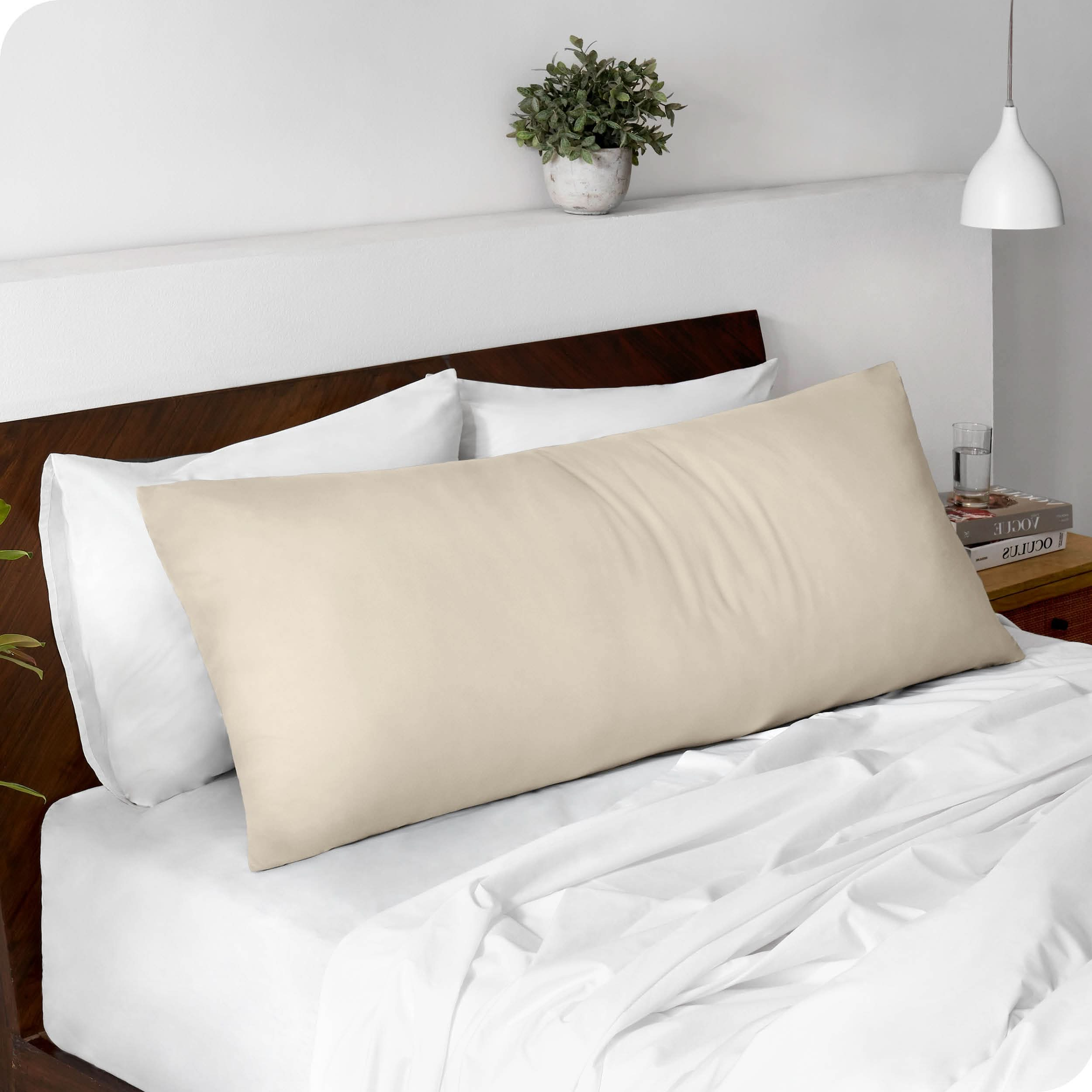 A body pillowcase on a pillow set against a headboard