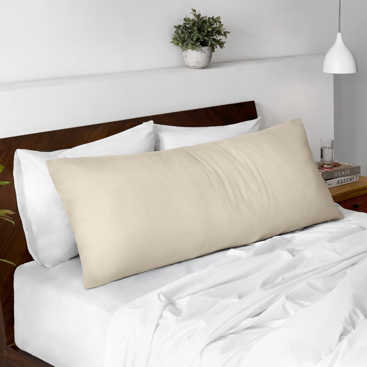 Body pillow on a bed with a wooden headboard and minimal decor.