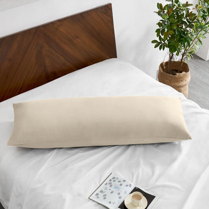 Pillowcase on a body pillow with a wooden headboard and plant in the background