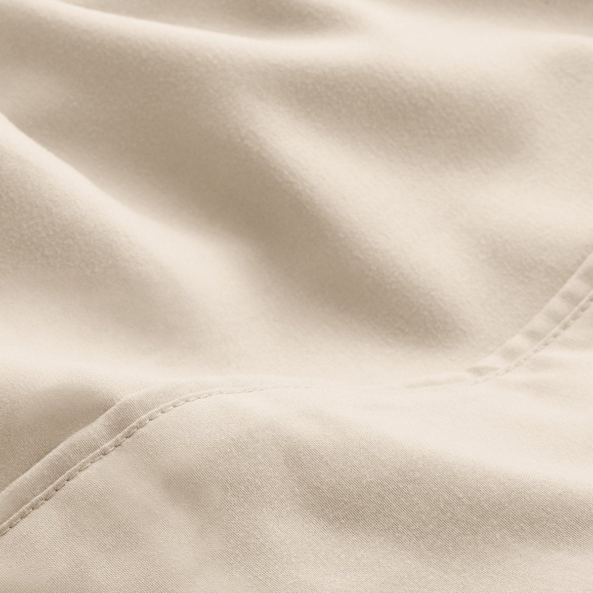 A close-up of microfiber fabric with soft folds and a visible stitched seam.