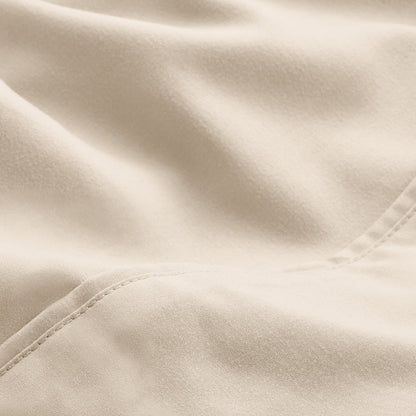 A close-up of microfiber fabric with soft folds and a visible stitched seam.