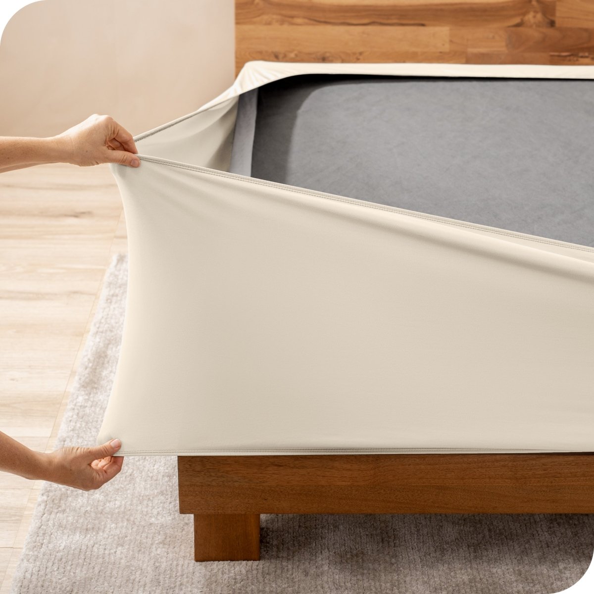 A person stretching a box spring cover