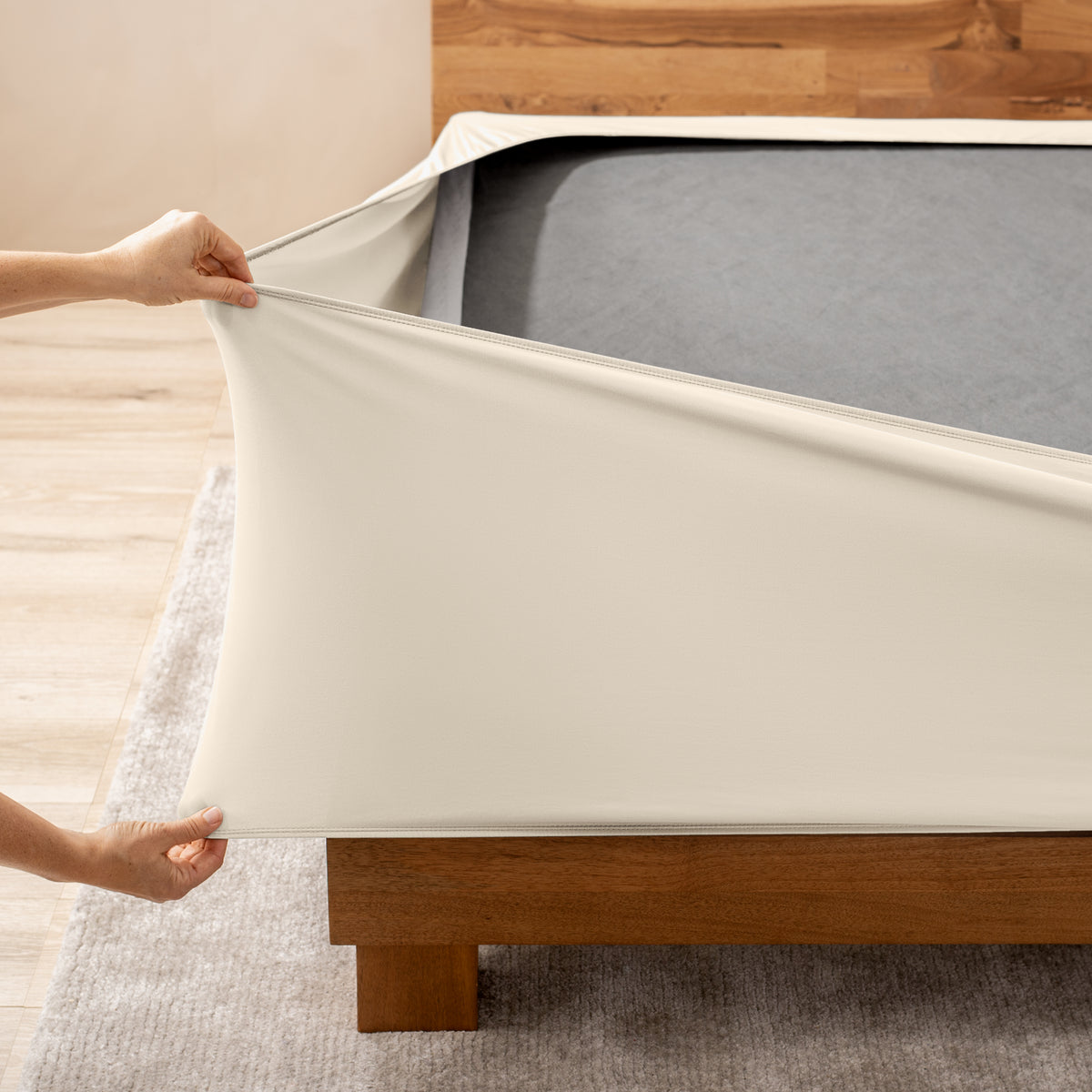 A person stretching a box spring cover