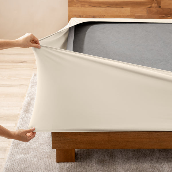 A person stretching a box spring cover