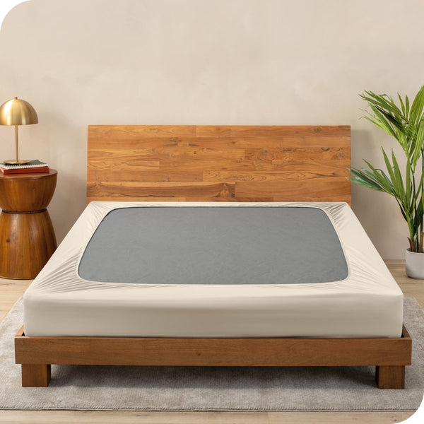 A cover on a box spring set on a wooden bed frame