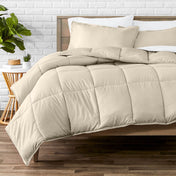 Comforter set on a bed with a white brick wall and plant in the background