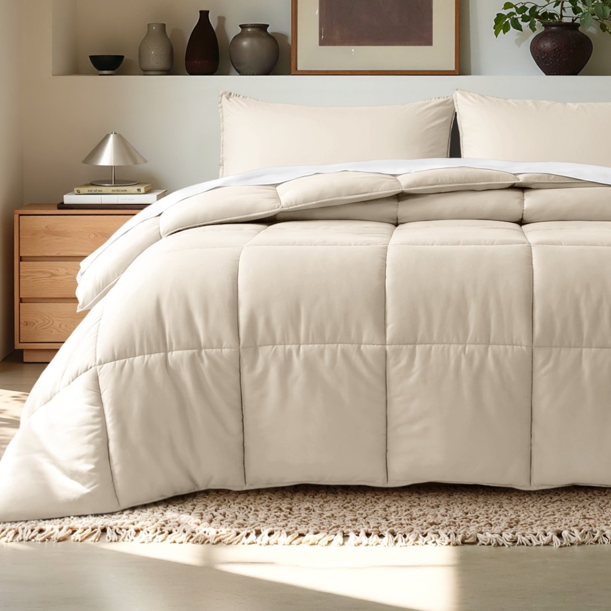 Comforter on a bed in a bedroom setting with a wooden nightstand and decorative items.