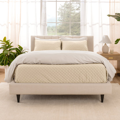 A bright bedroom with a coverlet set on the bed