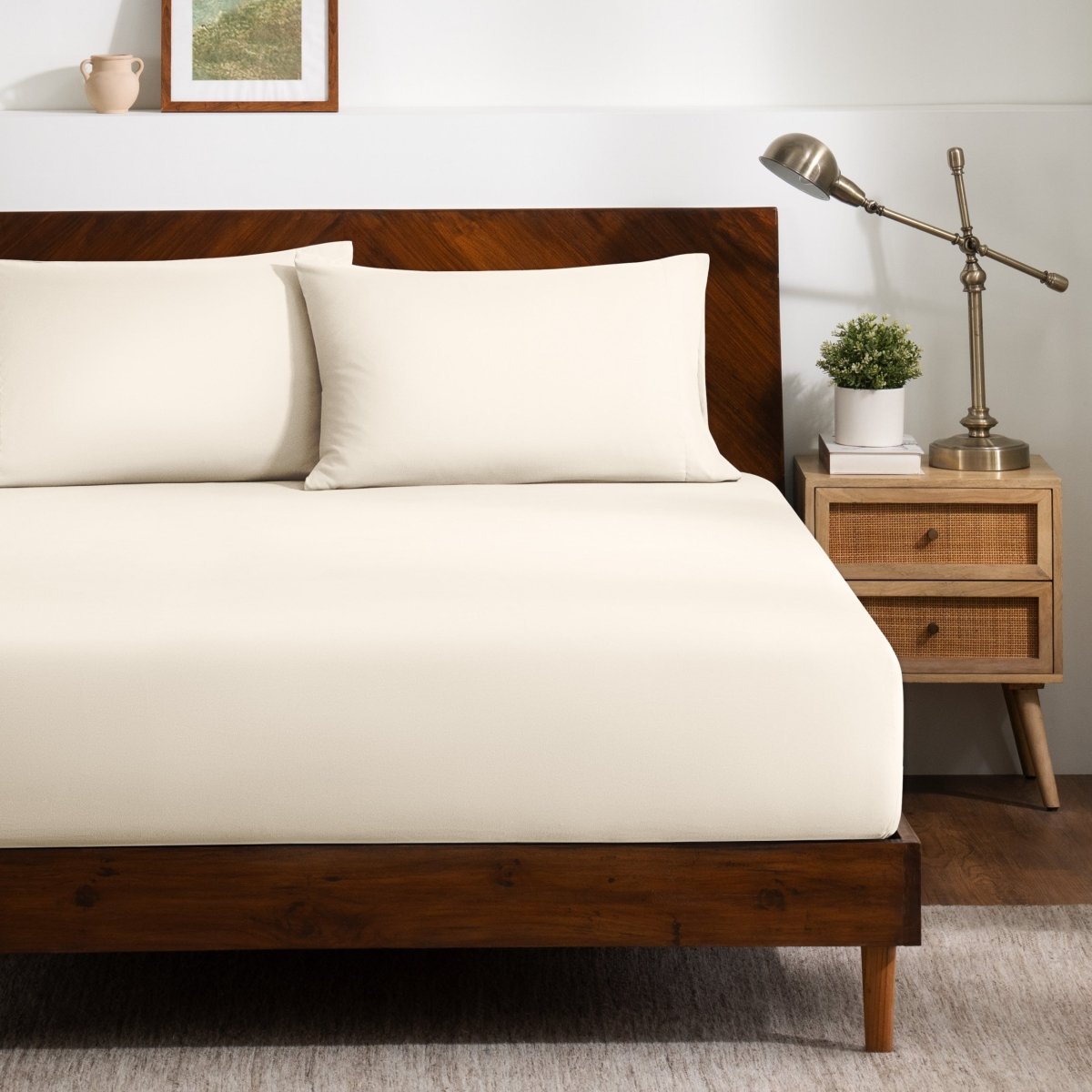 A bed dressed in a fitted sheet and two matching pillowcases.