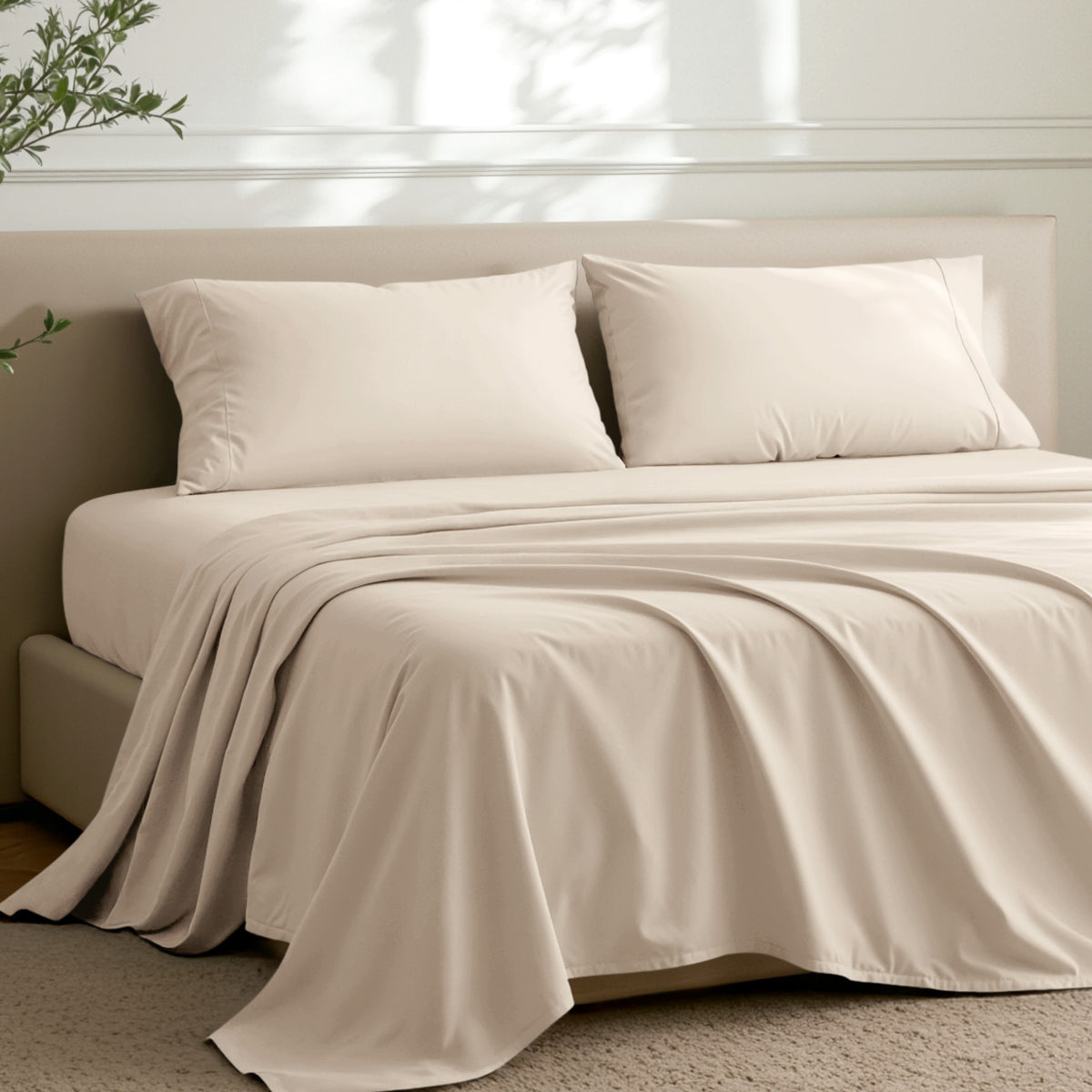 Microfiber sheets on a bed in a well-lit room with a plant.