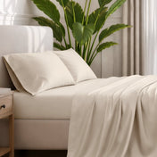 Ultra-soft sheets and pillowcases on a bed with a plant in the background