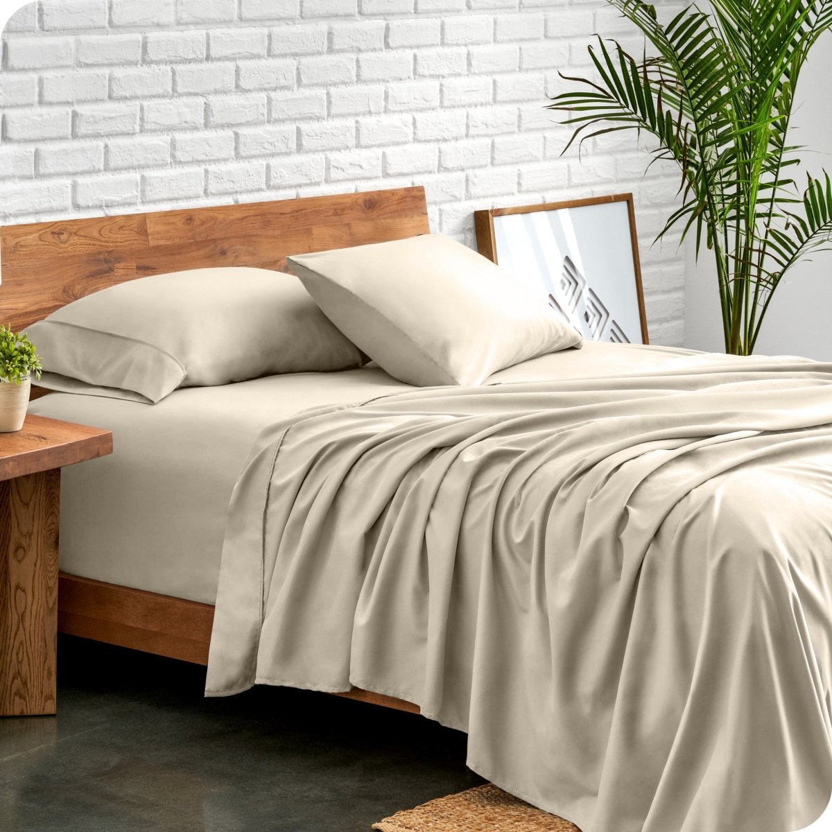 Bed with microfiber sheets against a white brick wall
