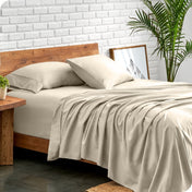 Bed with microfiber sheets against a white brick wall