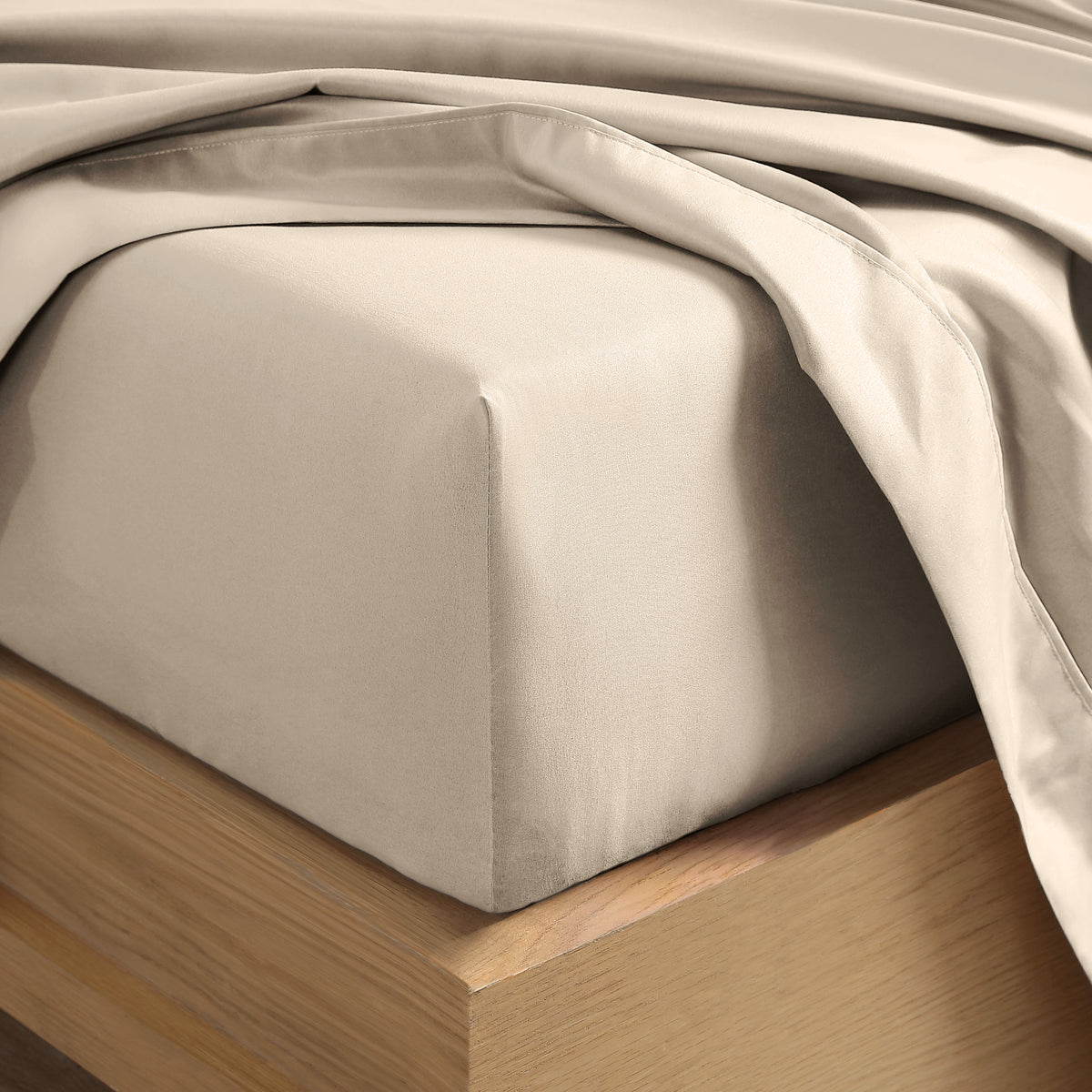 Close up of the corner of a mattress with a fitted sheet and flat sheet on it