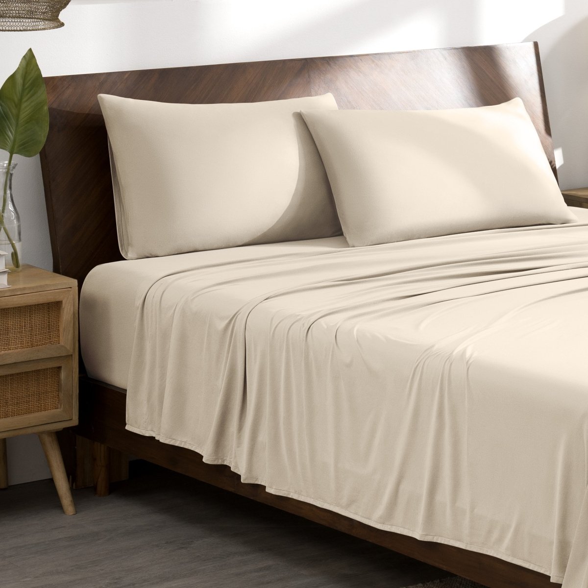 Microfiber stretch bed sheets and pillows on a wooden bed in a bedroom setting.