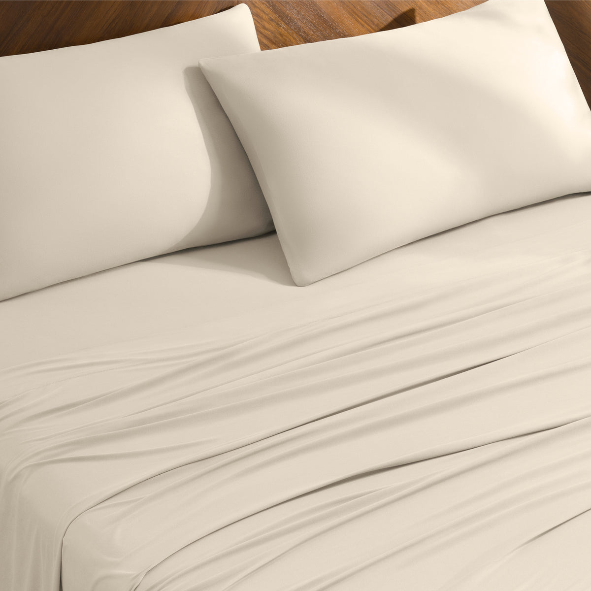 Bed sheets and pillowcases on a bed with a wooden headboard