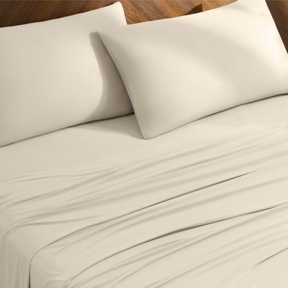 Bed sheets and pillowcases on a bed with a wooden headboard