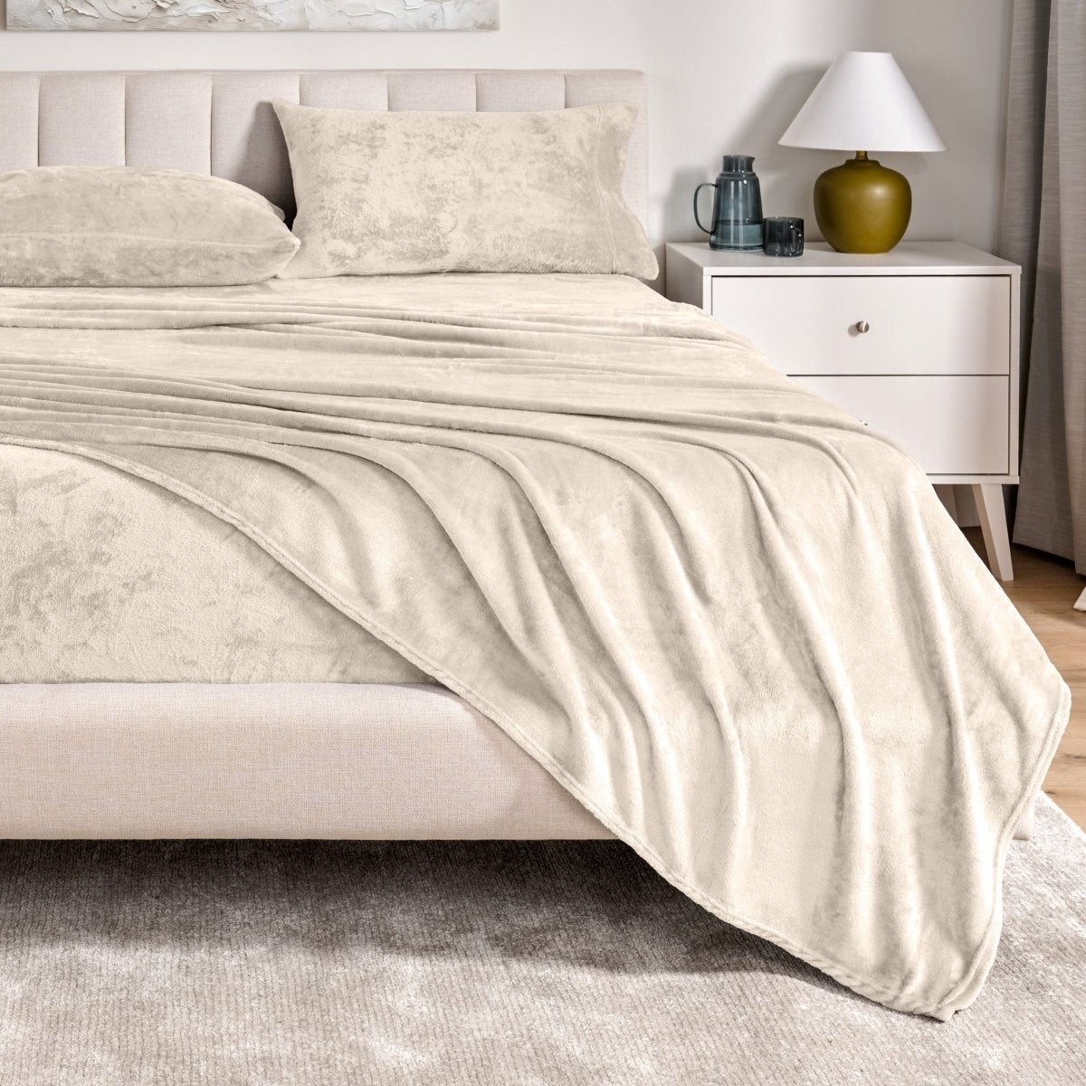 Microplush sheet set on a bed in a bedroom setting with a nightstand and lamp.