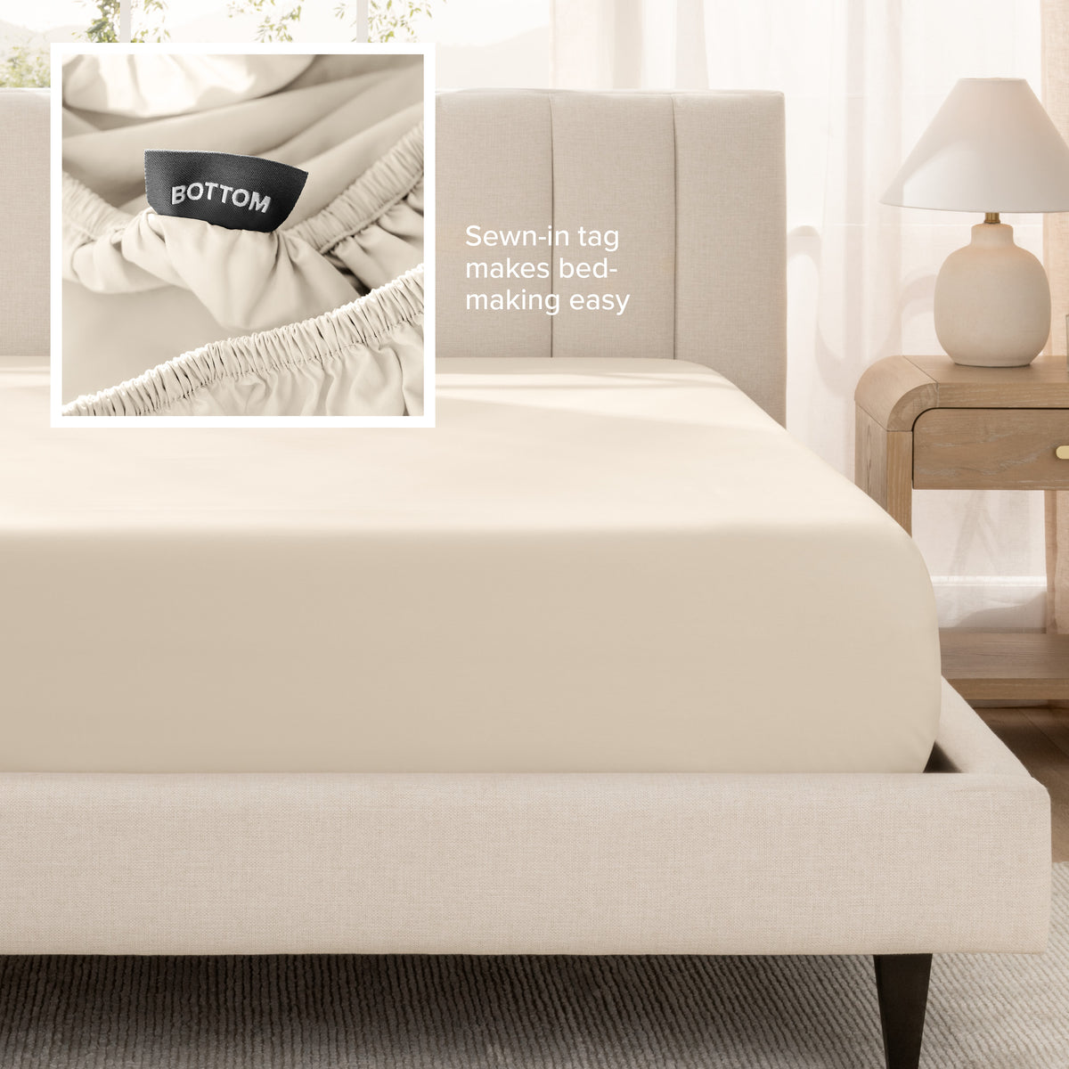 A fitted bed sheet shown on a bed. Text on the image says the sewn-in tag makes bed-making easy.