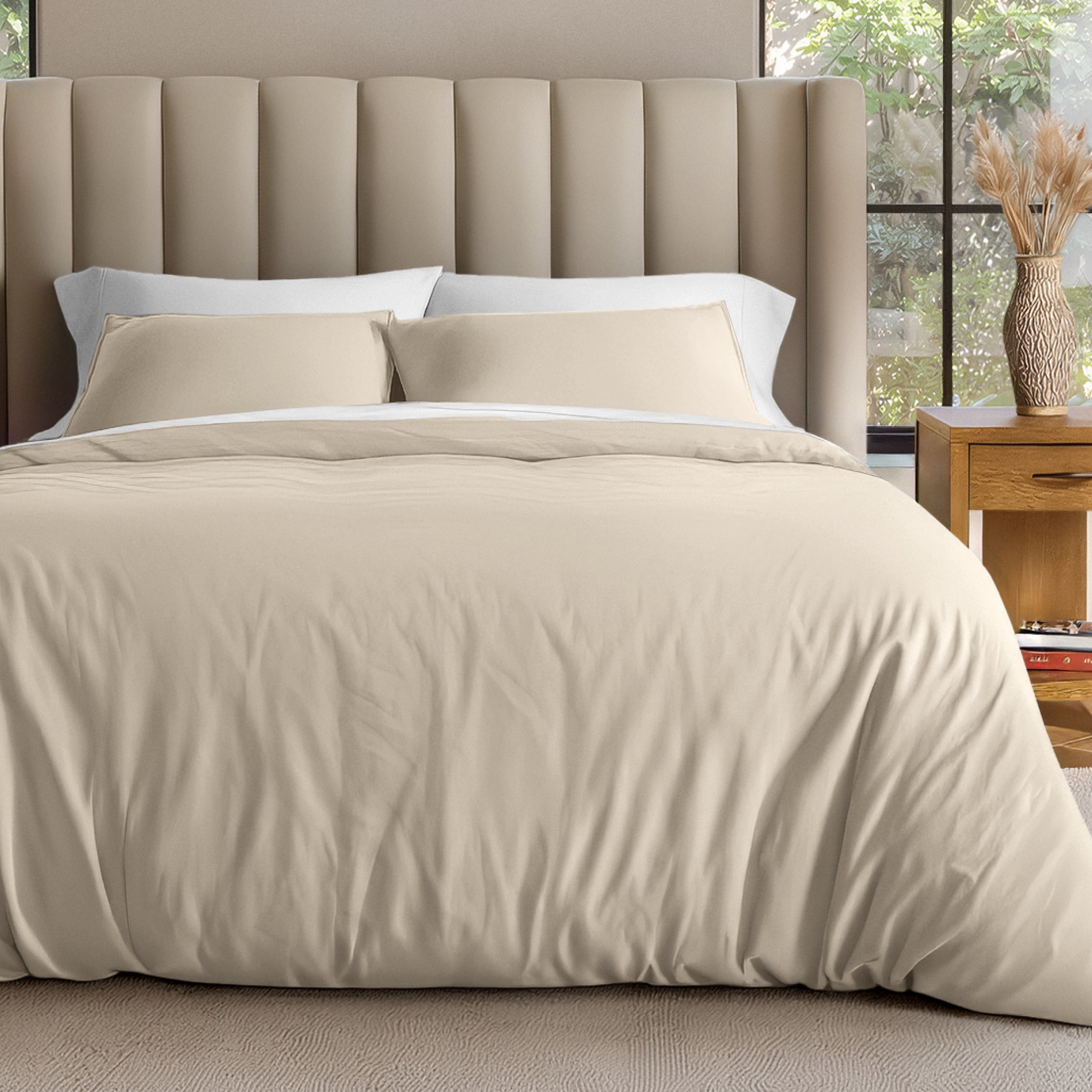 Neatly made bed with organic jersey bedding and pillow shams in a bedroom setting.