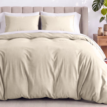 Neatly made bed with organic jersey bedding and pillow shams in a bedroom setting.
