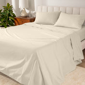 Percale sheets on a bed with a cream colored frame and headboard