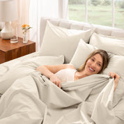 Woman lying in bed with percale bedding in a bright bedroom