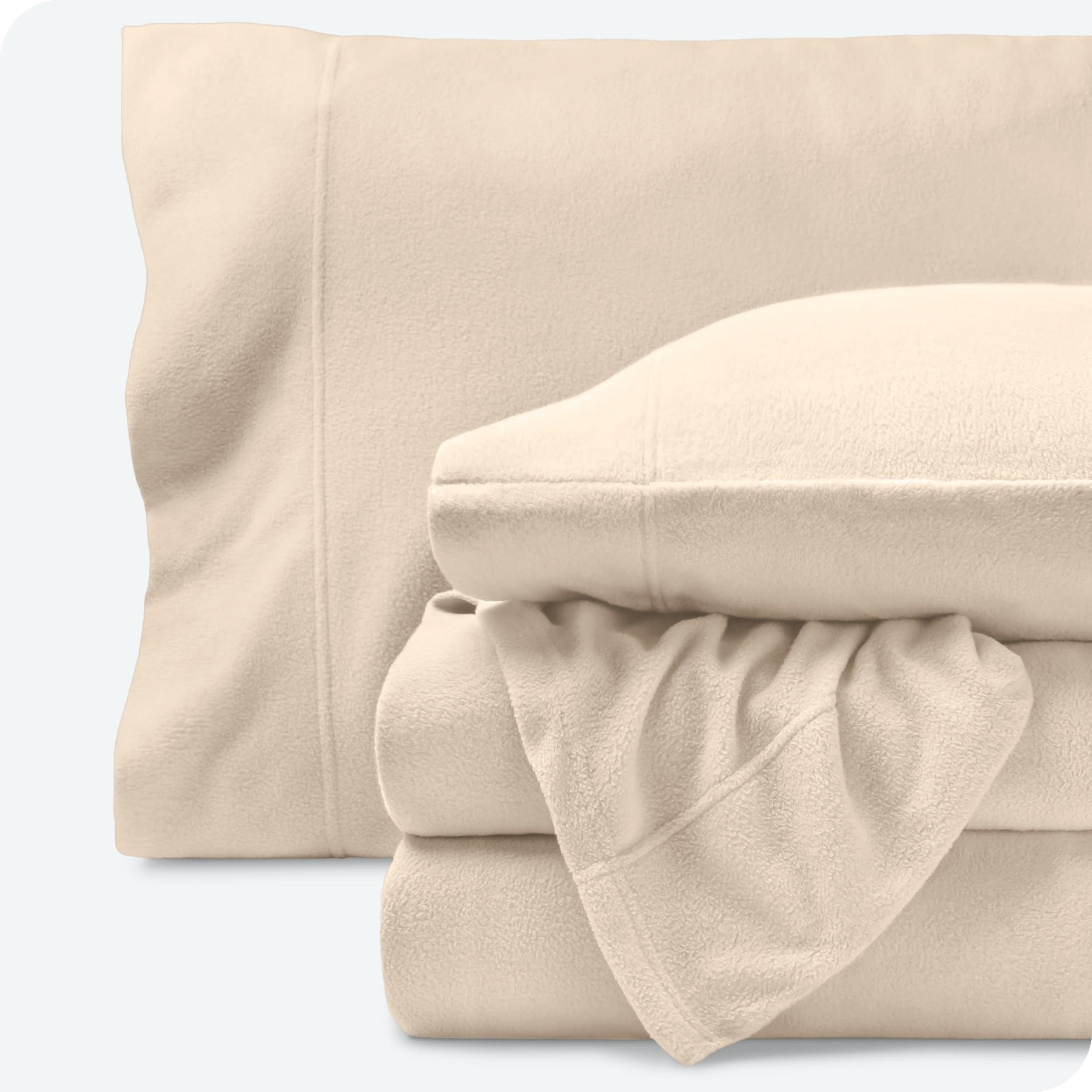 Fleece sheets folded neatly and stacked with pillows inside the pillowcases