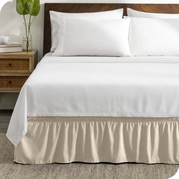 A wrap around bed skirt on a mattress with white bedding