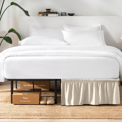 Bed with white bedding and a plant near the bed.