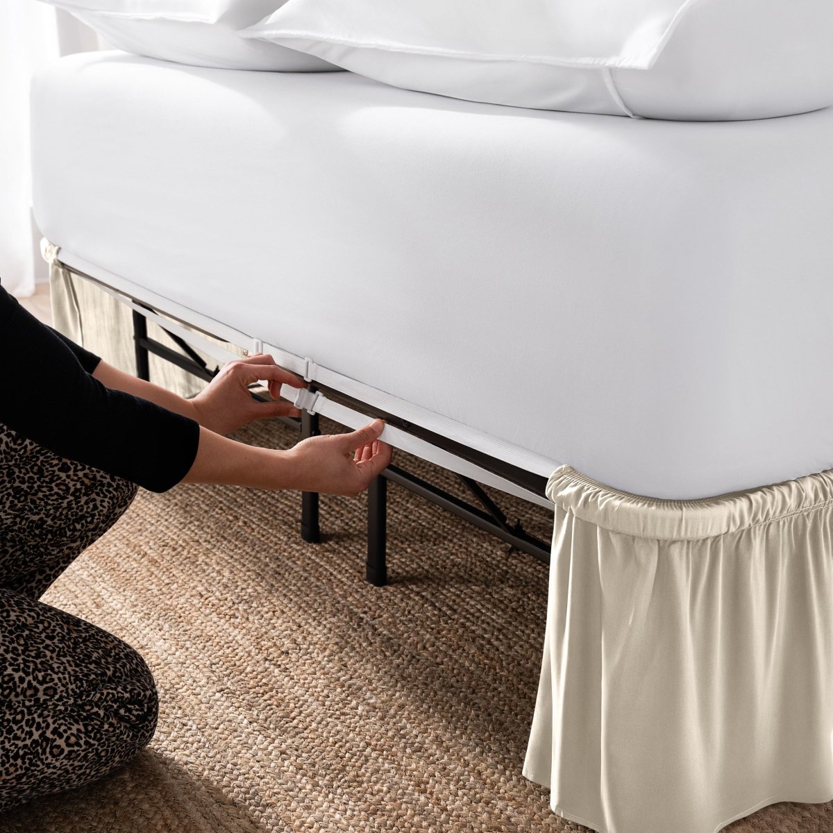 Adjustable bed skirt on a bed showing the elastic strap.
